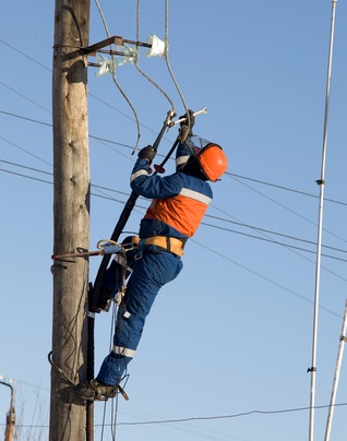 An electrical power line worker repairing a line