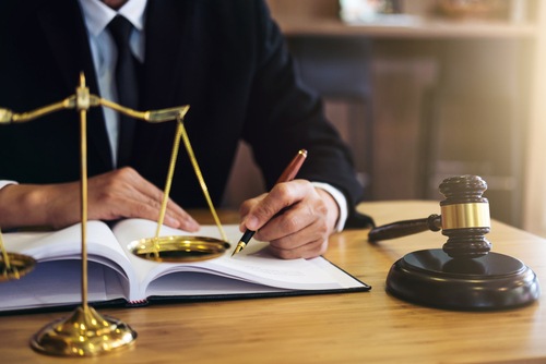 Lawyer sitting a desk with pen, paper and gavel